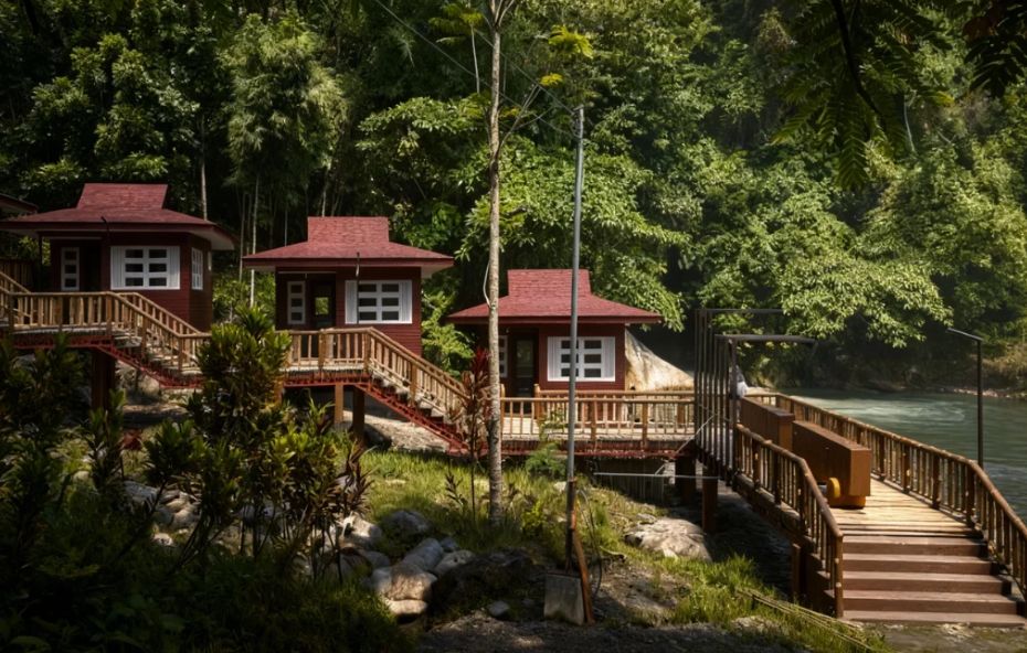Vista de três chalés de madeira com telhados vermelhos interligados por passarelas suspensas em meio a uma densa vegetação verde com um rio ao fundo sob a luz do sol.