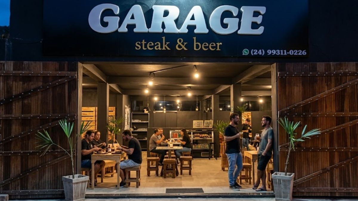 Fotografia noturna da fachada do restaurante Garage Steak & Beer em Ipiabas com as portas abertas revelando um interior movimentado com clientes jantando e conversando em mesas de madeira sob luzes quentes.