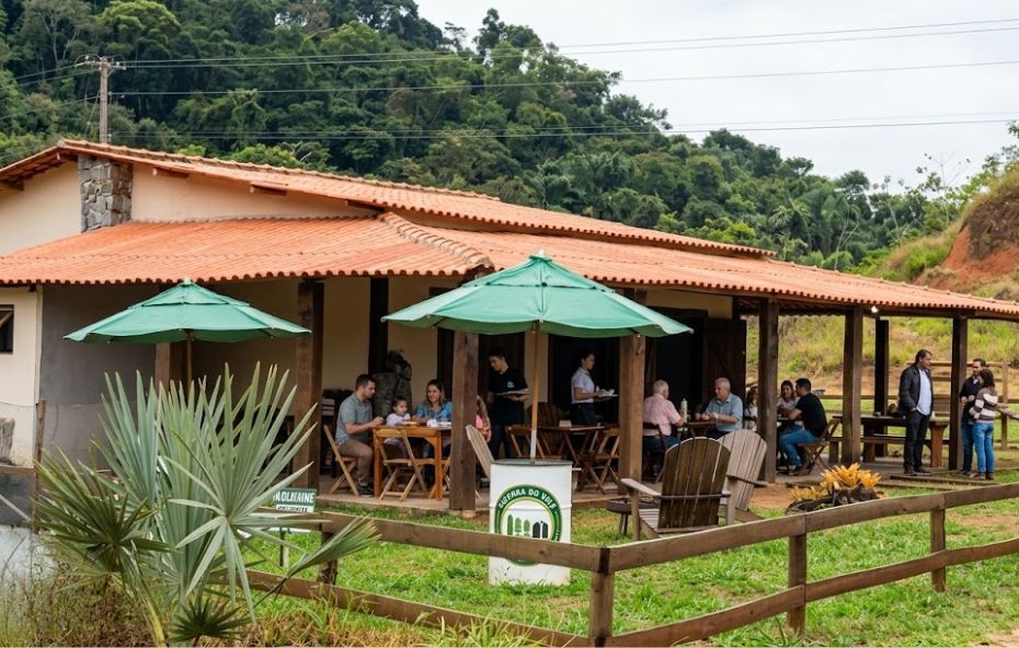 Fachada rústica do Restaurante Fazenda do Vale com clientes na varanda.