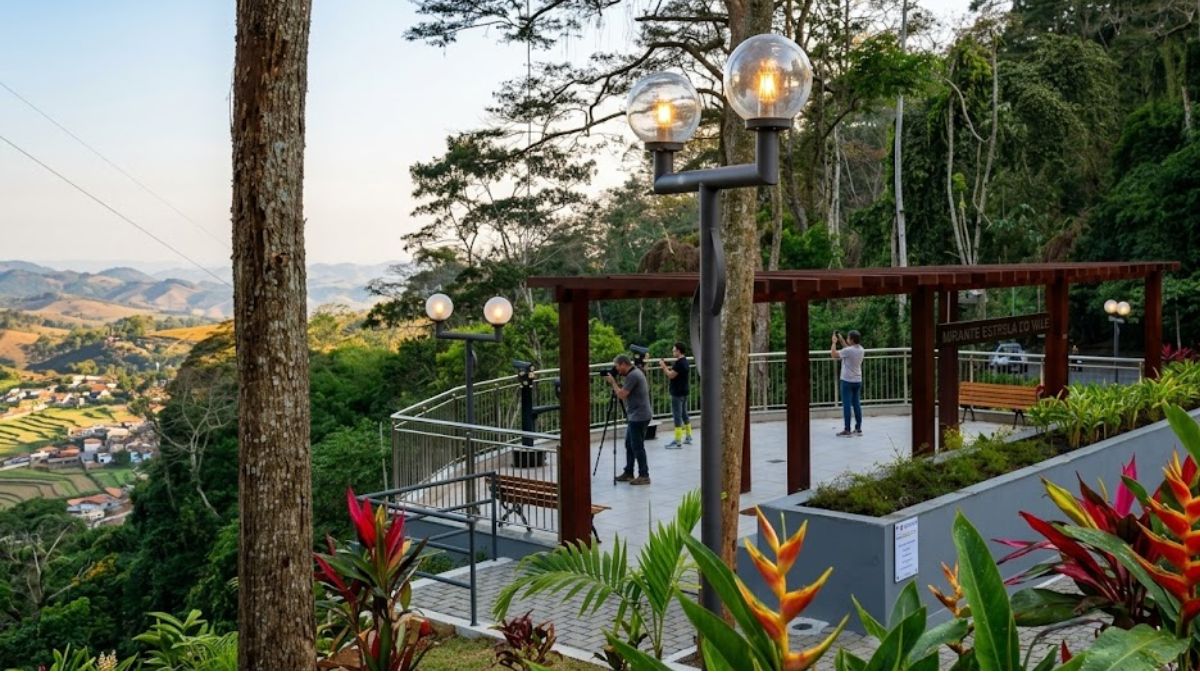 Vista panorâmica do Mirante Estrela do Vale em Ipiabas, mostrando a plataforma de observação com turistas, postes de luz acesos e a paisagem montanhosa ao fundo.