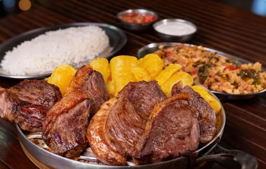 Vista detalhada de um churrasco tradicional sendo preparado em uma grelha rústica, com cortes de carne suculenta e acompanhamentos típicos, em um ambiente que remete às antigas fazendas históricas de Ipiabas.