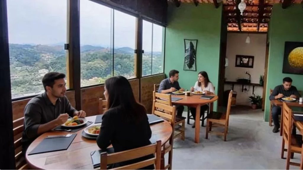 Ambiente interno do Armazém da Colina com clientes almoçando, mesas de madeira e vista panorâmica para as montanhas de Ipiabas.