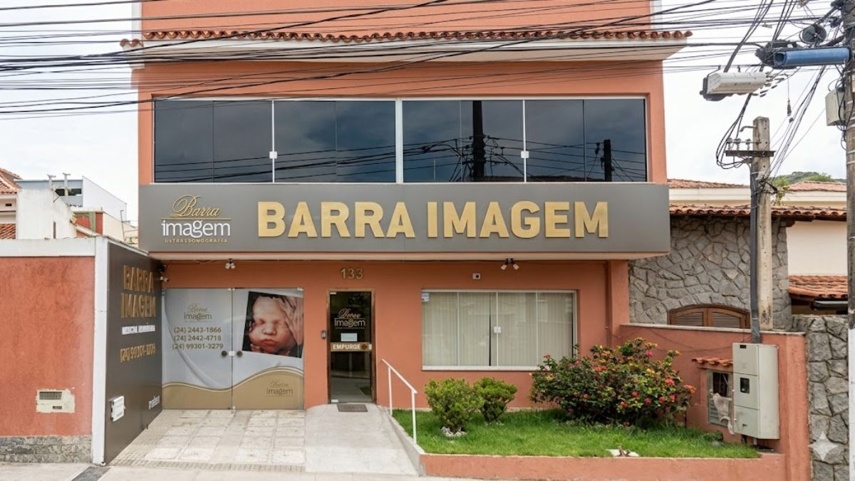 Fotografia da fachada da clínica Barra Imagem com placa cinza e letras douradas exibindo o endereço número cento e trinta e três.