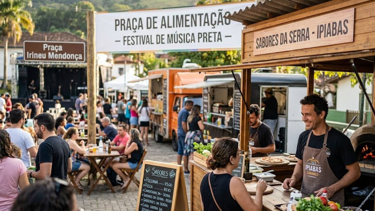 Uma foto de uma movimentada praça de alimentação ao ar livre em uma praça pavimentada em Ipiabas. Ao fundo, uma grande faixa branca sobre postes de madeira diz PRAÇA DE ALIMENTAÇÃO - FESTIVAL DE MÚSICA PRETA. À direita, um quiosque de madeira tem uma placa que diz SABORES DA SERRA - IPIABAS e apresenta um chef sorridente em um avental com o logotipo IPIABAS SABORES preparando pizzas em um forno a lenha. À esquerda, uma placa marrom e branca menor em um poste diz Praça Irineu Mendonça. Diversas pessoas estão sentadas em mesas de madeira sob o sol, e vários food trucks estão estacionados ao longo da praça.