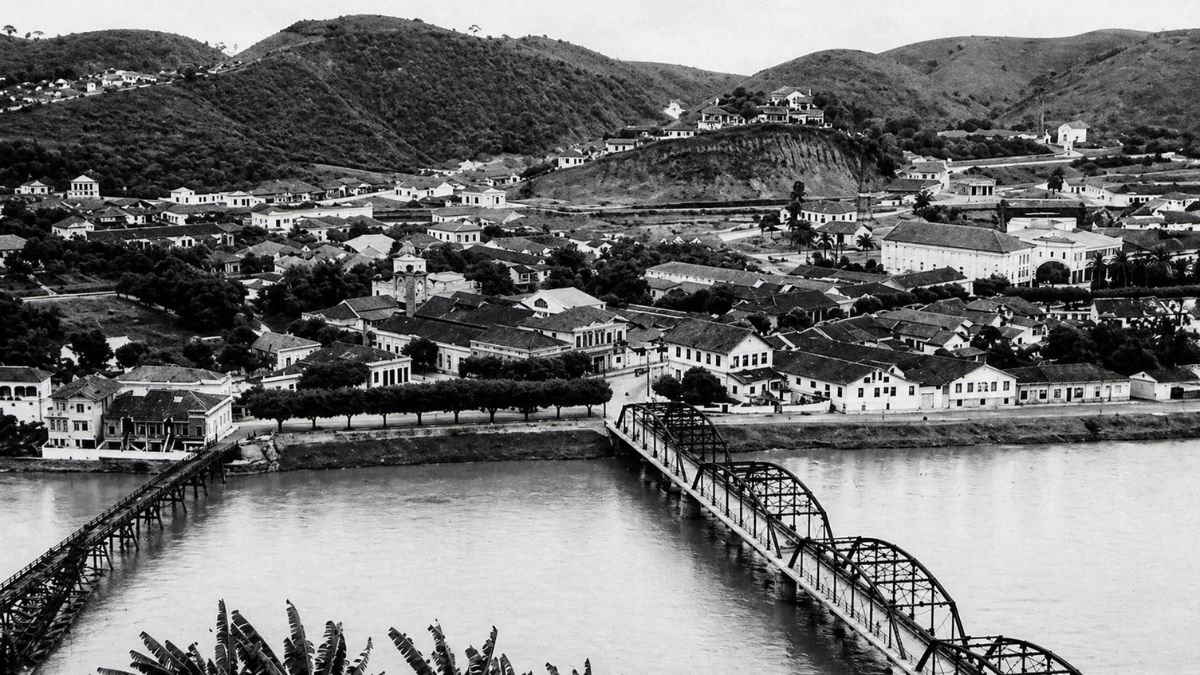 Fotografia aérea antiga em preto e branco mostrando a cidade de Barra do Piraí com pontes sobre o rio Paraíba.