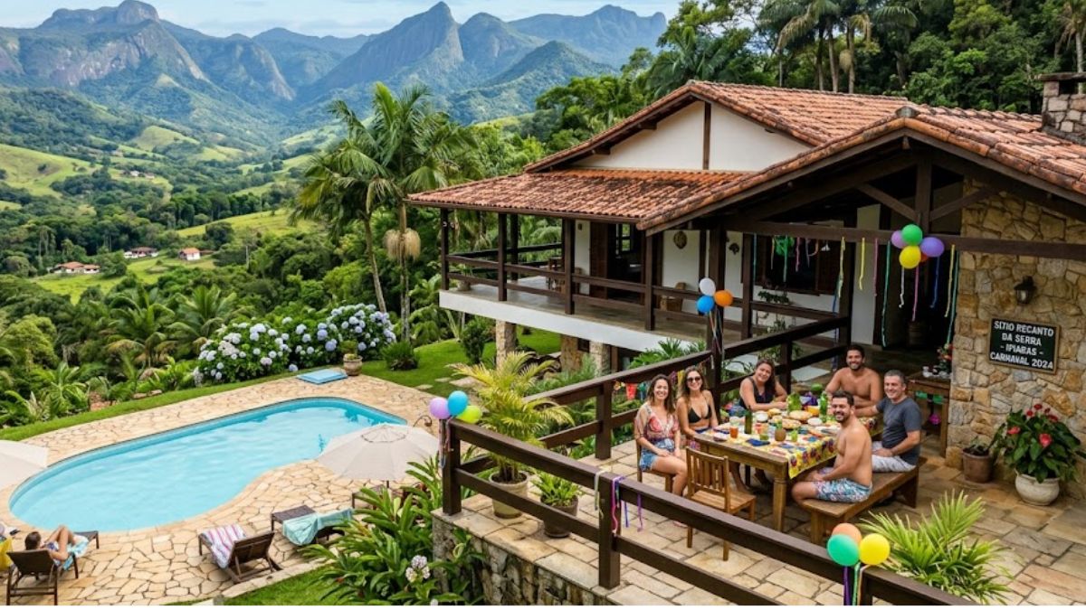 Uma foto de ângulo elevado captura uma casa de fazenda rústica em Ipiabas com um grupo de pessoas almoçando na varanda ao lado de uma piscina azul clara e montanhas exuberantes ao fundo.