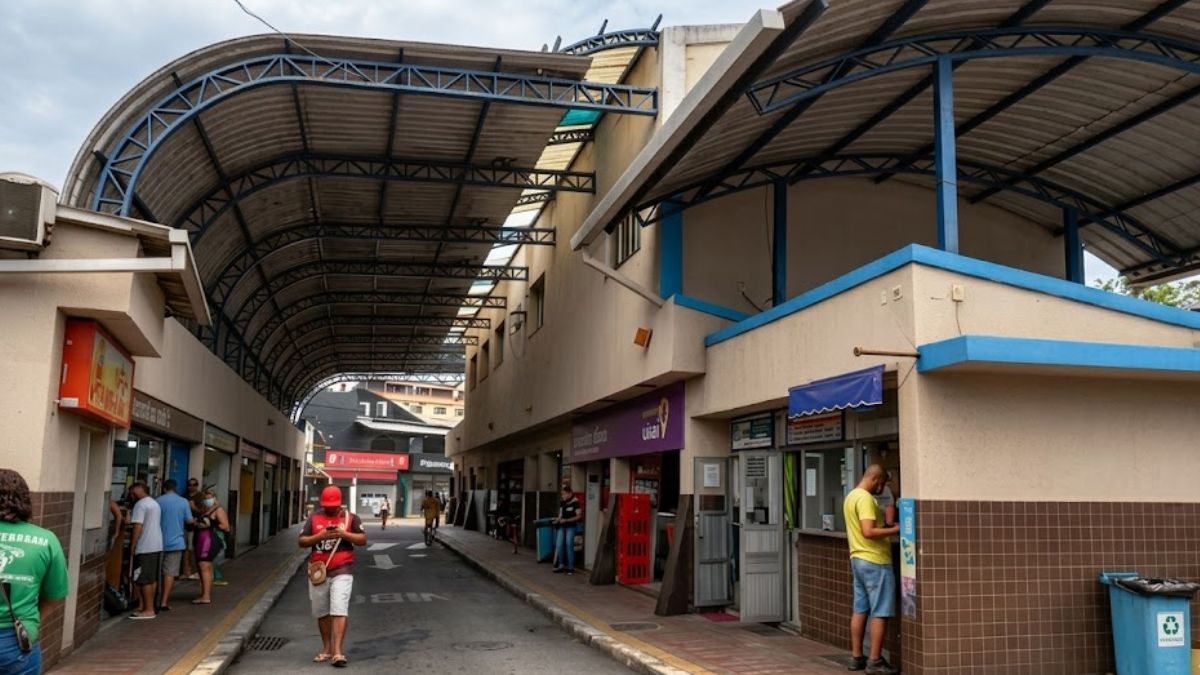 Fotografia profissional em ângulo médio mostrando o corredor central da Rodoviária de Barra do Piraí com guichês e cobertura metálica.