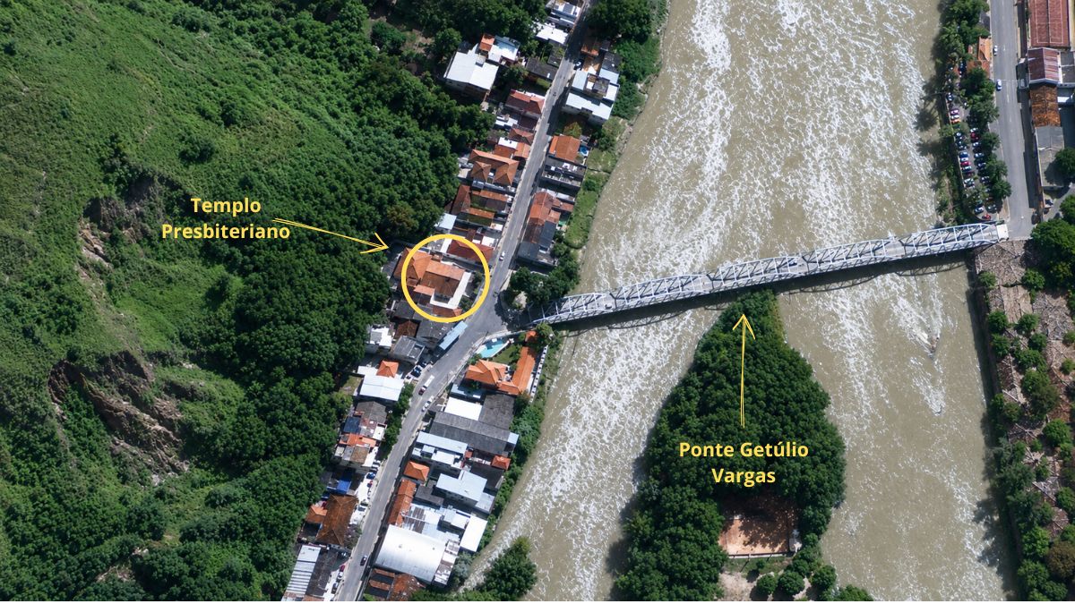 Vista aérea mostrando o Templo Presbiteriano destacado por um círculo amarelo próximo à Ponte Getúlio Vargas sobre o rio. O entorno possui vegetação densa e ocupação urbana linear ao longo da via.