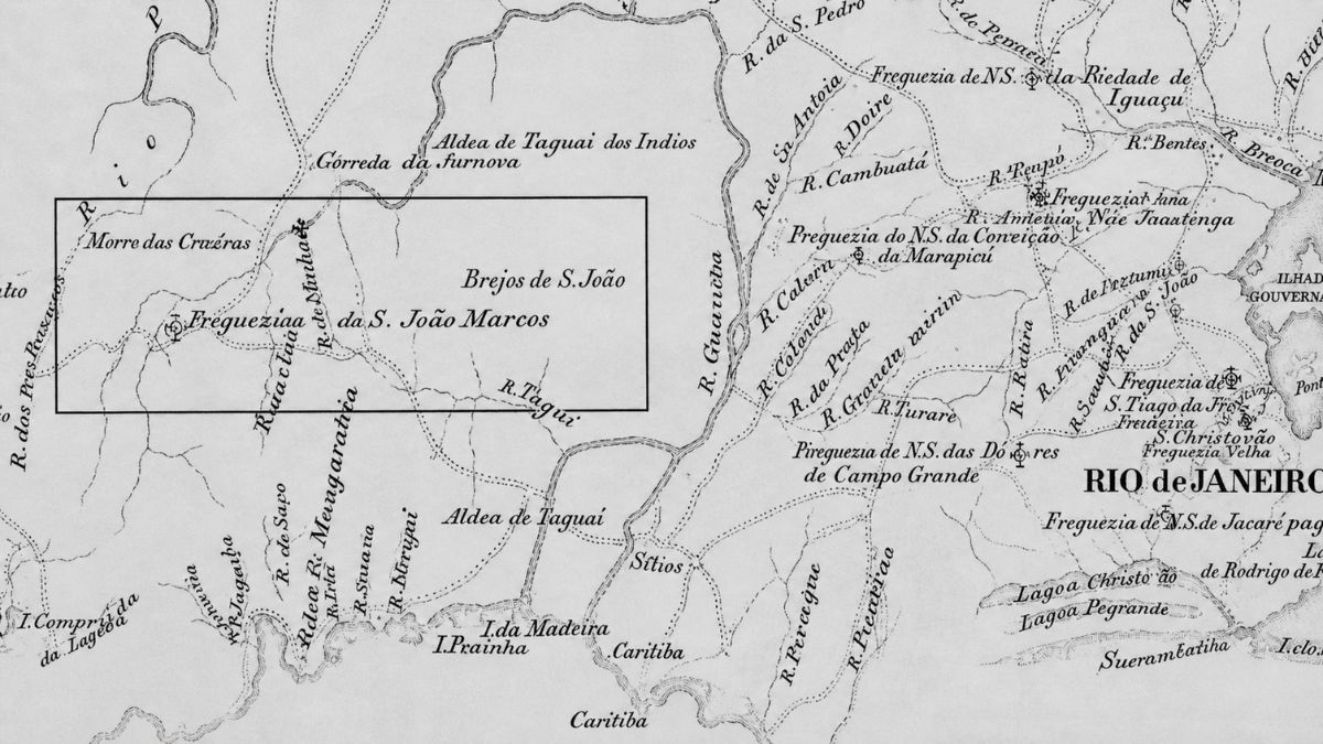 Mapa histórico em tons de cinza com foco na região de São João Marcos, delimitada por um retângulo preto central. O mapa exibe hidrografia detalhada com rios como o Taguai e o Guariciba, além de nomes de localidades em caligrafia cursiva antiga como Brejos de São João e Aldea de Taguai. À direita, observa-se a indicação da cidade do Rio de Janeiro e diversas freguesias como Campo Grande e Jacarepaguá. O relevo é indicado por hachuras leves e a costa litorânea aparece na parte inferior com as ilhas da Madeira e Prainha.
