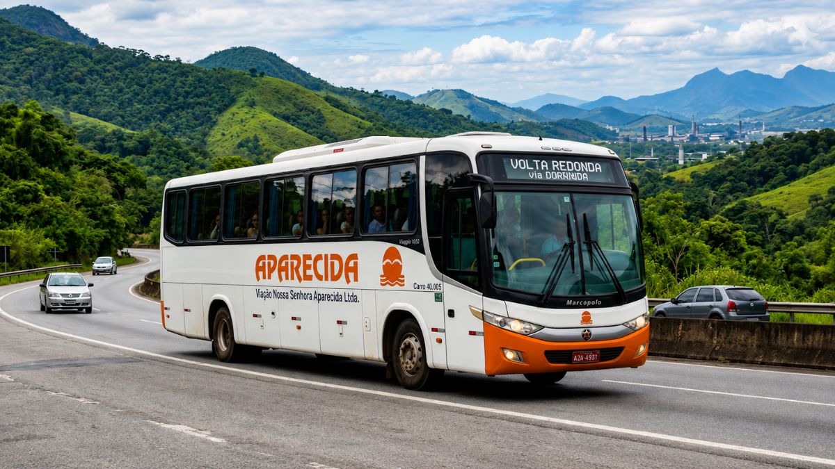 Ônibus branco da Viação Aparecida com detalhes laranjas circulando em rodovia cercada por montanhas e vegetação sob céu nublado.
