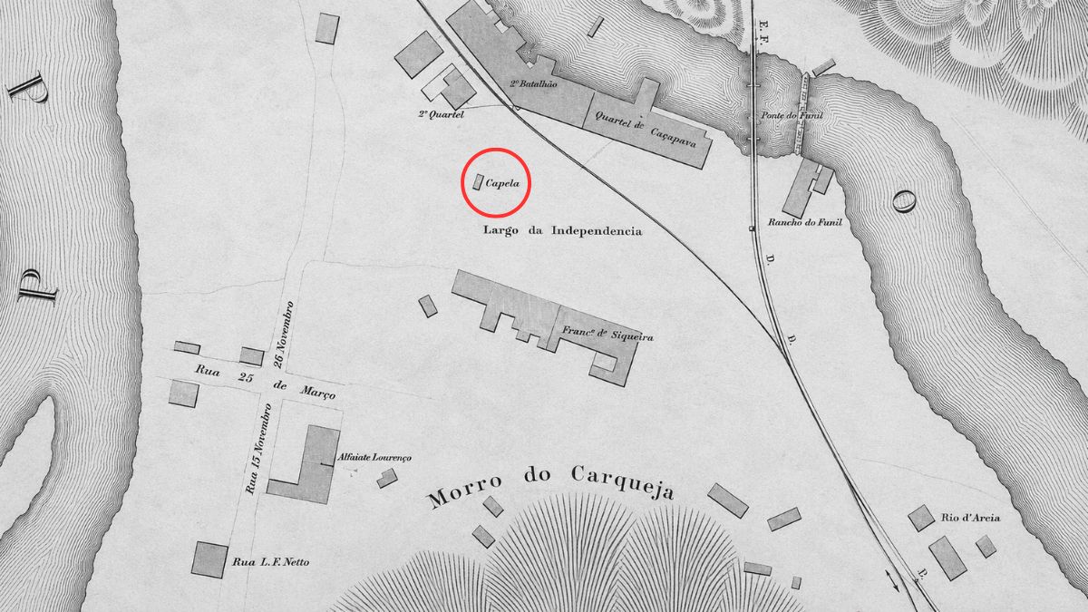 Mapa antigo em tons de cinza com nomes de ruas e rios apresentando a localização de uma capela circulada em vermelho.