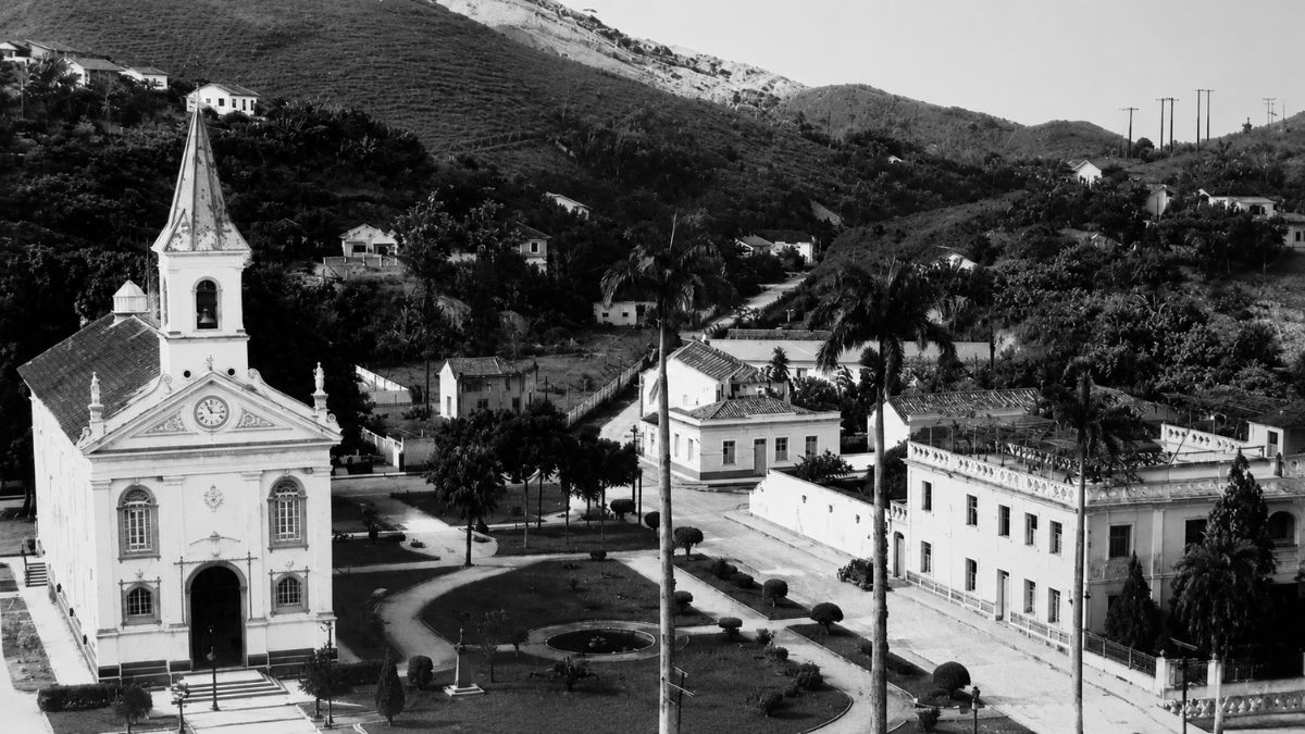 Fotografia antiga em preto e branco mostrando a Catedral de Santana à esquerda, uma praça central e o Palácio Episcopal à direita.