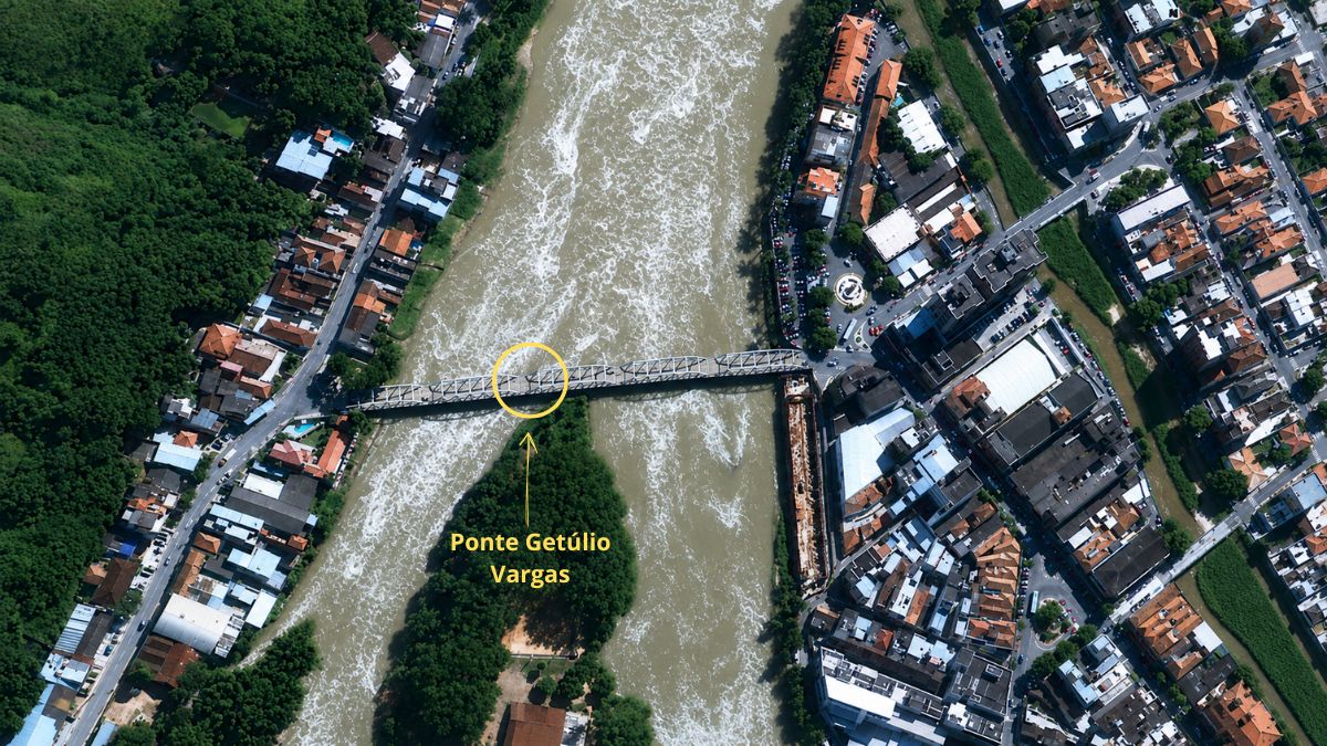 Foto aérea da Ponte Getúlio Vargas cruzando o Rio Paraíba do Sul conectando áreas urbanas com densa vegetação e ilha fluvial.